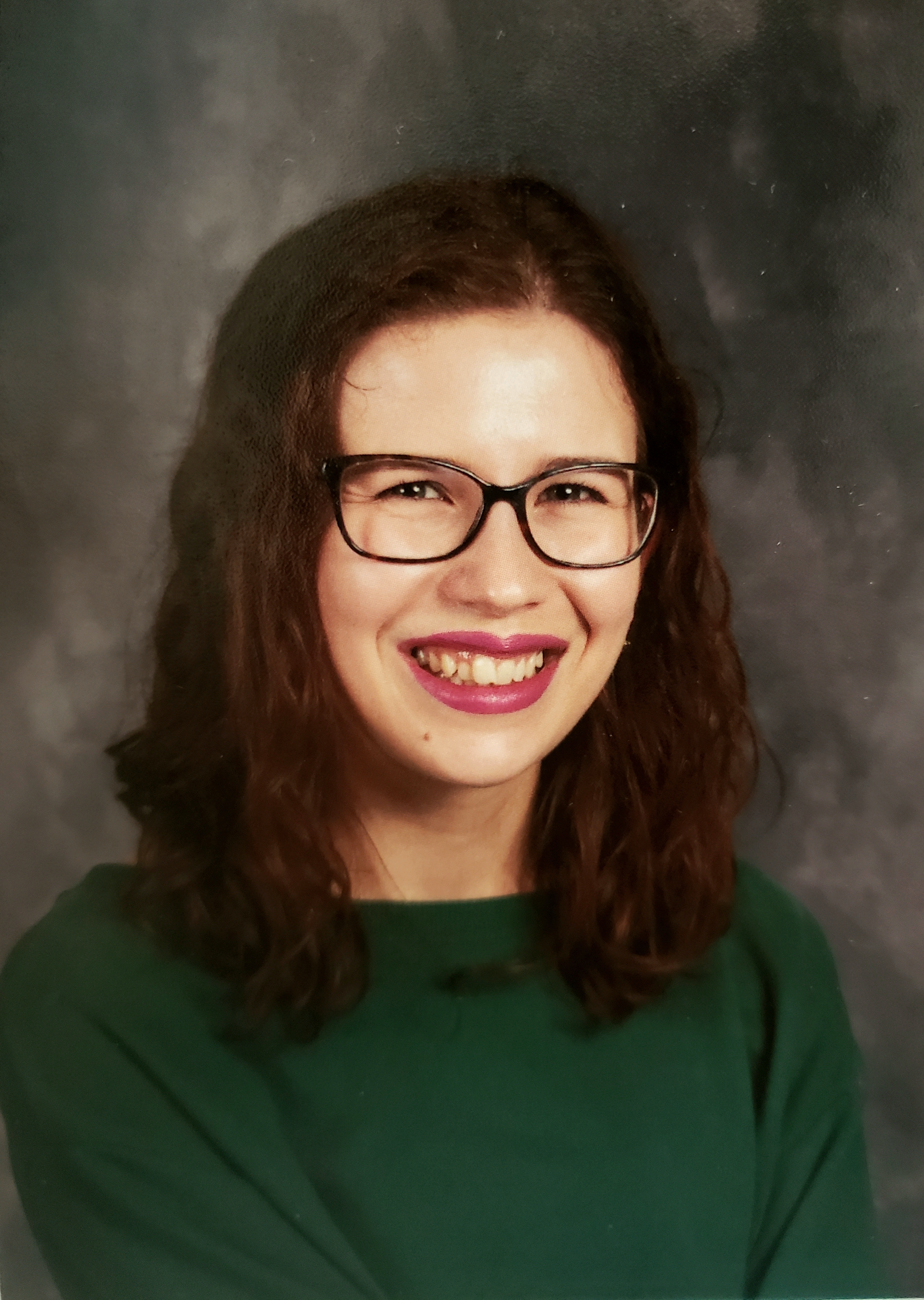 Headshot of Andrea S. Barrios in front of a gray background